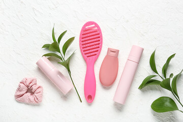 Composition with hair brush, scrunchy and cosmetic products on light background