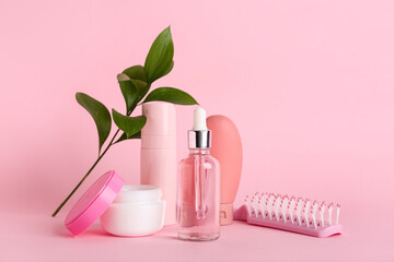 Composition with hair brush, cosmetic products and plant branch on pink background