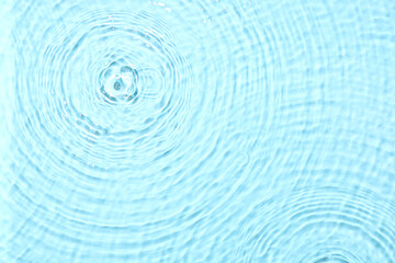 Water with splashes on blue background, top view