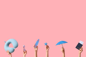Female hands with beach accessories on pink background. Tourism concept