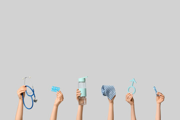 Female hands with medical supplies, symbol of man and blue ribbon on light background. Prostate...