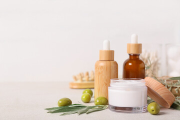 Set of natural cosmetic products and green olives on light table
