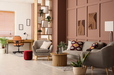 Interior of stylish living room with grey sofa, armchairs, coffee table and workspace