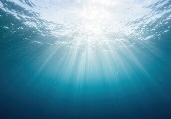 Underwater view of sunlight rays penetrating the clear blue ocean surface