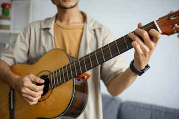 Obraz premium Young Man's Hands Playing Chords On Acoustic Guitar