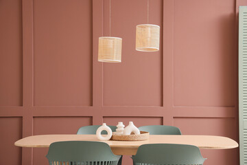 Interior of stylish dining room with wooden table, chairs and lamps