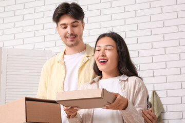 Happy young couple with parcel boxes in kitchen