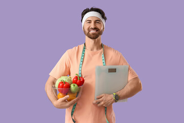Sporty young man with weight scales and healthy food on lilac background