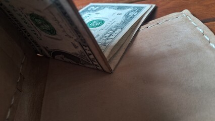 Elegant leather wallet with dollar bills inside