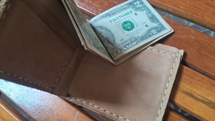 Elegant leather wallet with dollar bills inside