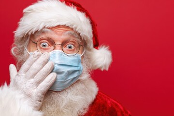 Elderly man in Santa costume masked and shocked peeking through his fingers