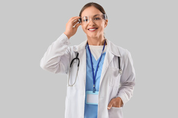 Female doctor in goggles on light background