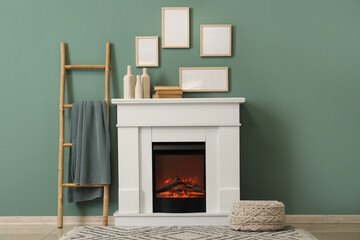 Interior of living room with ladder, ottoman and home decor on fireplace near blue wall