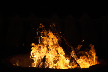 Bonfire in the black night sky, with intense flames and heat rising. A warm, dangerous inferno...