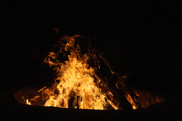 Abstract photo of fire at night with vivid flames and smoke. The inferno burns with intense heat,...