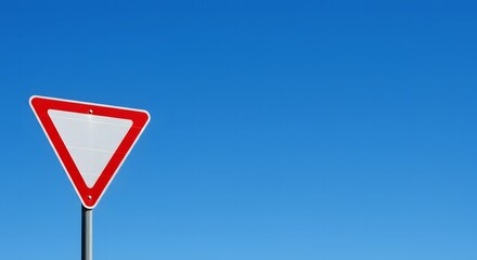 Yield Sign Against Blue Sky: A close-up shot features a sharp, triangular yield sign, its bright red border and white interior perfectly contrasting against the clear, serene blue sky.