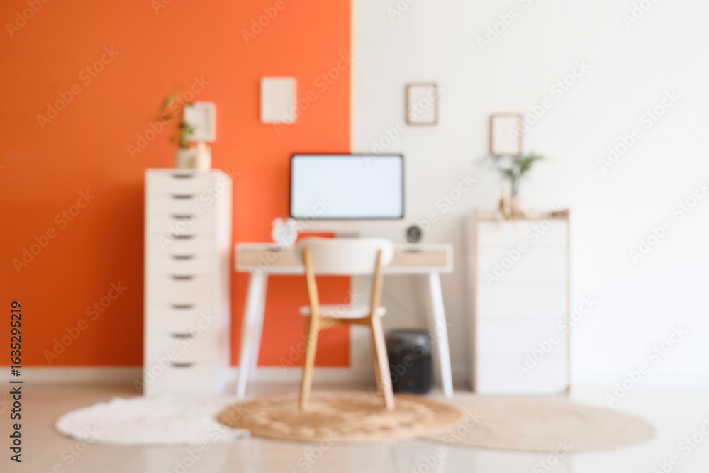 Aufkleber blurred view of comfortable workspace with modern computer and houseplants near color wall