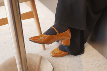 Stylish brown high heel shoes on a seated individual
