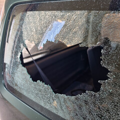 Thief broken car window. Criminal incident and vandalism on the city streets.