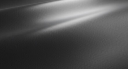 Fototapeta premium A detailed dark grey brushed metal background. The sleek surface has a smooth light reflection, creating a modern, industrial, and luxurious abstract texture for any design.