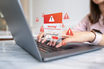 Company employee using laptop computer with warning spyware detected on your computer, cybersecurity alert, spam risk concept