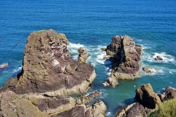 Rugged coastal rock formations against the deep blue sea showcasing natural beauty and tranquility.