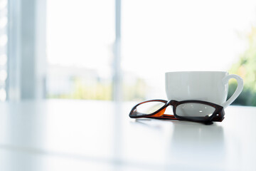 A hot cup of coffee on a morning table with a newspaper in a cozy cafe or office setting