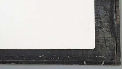 A blank white canvas or board is shown from the bottom right corner, partially framed by a dark,...