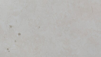 A close-up of a rustic, textured wall with subtle color variations and small imperfections. The...
