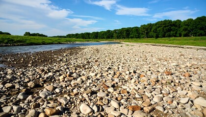 Scenic view of a rocky riverbank with clear sky and lush green landscape