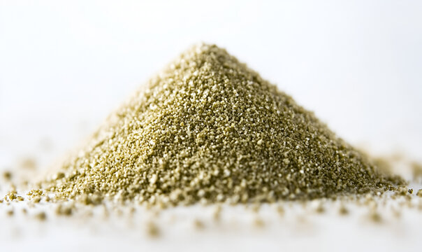 A detailed macro shot of a conical pile of fine greenish-gold granular powder isolated on a bright white background.