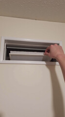 Clean Air Filter Being Inserted into Rectangular Wall Vent