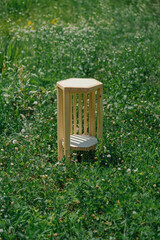 Wooden pedestal table on meadow. A rustic piece, ideal for outdoor display, blends with nature.