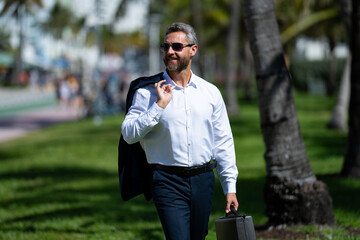Hot business. Summer business. Businessman on palm trees. Businessman in summer. Mature...