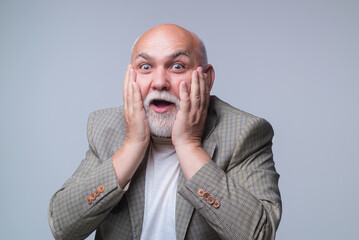 Senior man with shocked facial expression. Shocked pensioner man. Elderly male showing emotional...