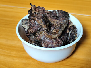 Fried beef lung with flour, has a delicious and delicious taste, served in a white bowl on a wooden table.