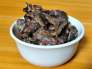 Fried beef lung with flour, has a delicious and delicious taste, served in a white bowl on a wooden table.