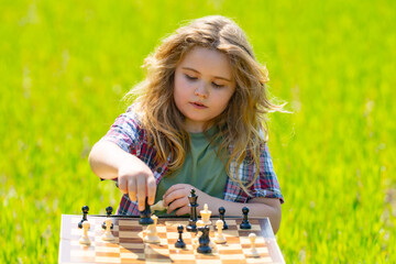 Kid plays chess. A child thinks and playing chess. Kid focuses on chessboard. The kid make...