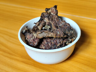 Fried beef lung with flour, has a delicious and delicious taste, served in a white bowl on a wooden table.