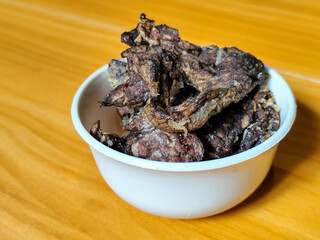 Fried beef lung with flour, has a delicious and delicious taste, served in a white bowl on a wooden table.