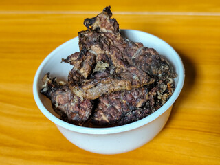 Fried beef lung with flour, has a delicious and delicious taste, served in a white bowl on a wooden table.