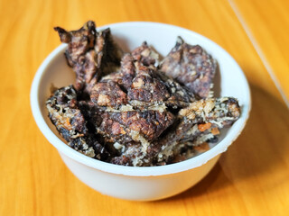Fried beef lung with flour, has a delicious and delicious taste, served in a white bowl on a wooden table.