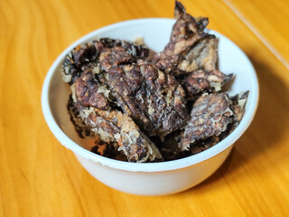 Fried beef lung with flour, has a delicious and delicious taste, served in a white bowl on a wooden...