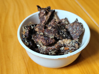 Fried beef lung with flour, has a delicious and delicious taste, served in a white bowl on a wooden table.