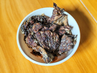 Fried beef lung with flour, has a delicious and delicious taste, served in a white bowl on a wooden table.