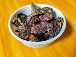 Fried beef lung with flour, has a delicious and delicious taste, served in a white bowl on a wooden table.