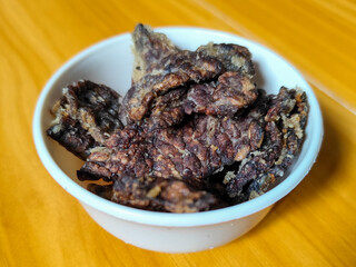 Fried beef lung with flour, has a delicious and delicious taste, served in a white bowl on a wooden table.