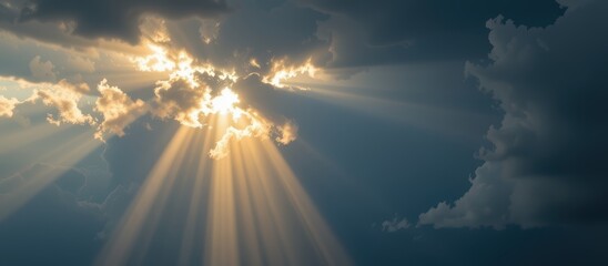 Dramatic sunlight breaking through clouds in a blue sky.