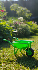 Photo of Green Wheelbarrow on Grassy Lawn under Sunlight in a Garden