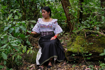 Indigenous woman wearing traditional clothes exploring lush forest